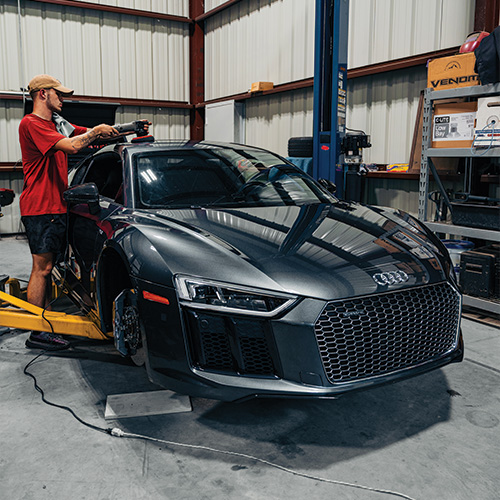 Auto Detailing San Antonio - A worker waxing and buffing a high-end sports car.