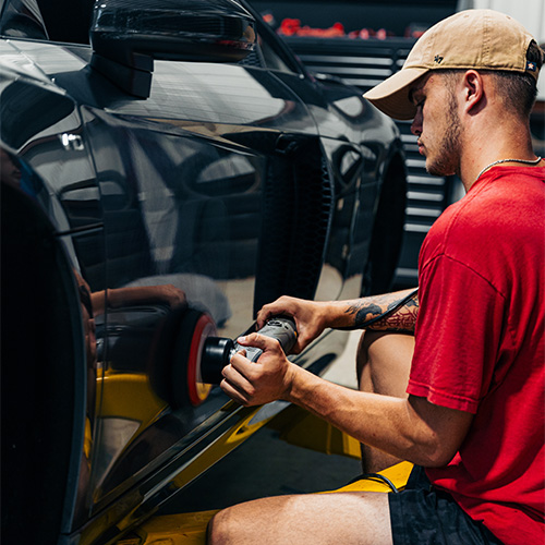 San Antonio Ceramic Coating - A worker buffing a newly coated European sports car.